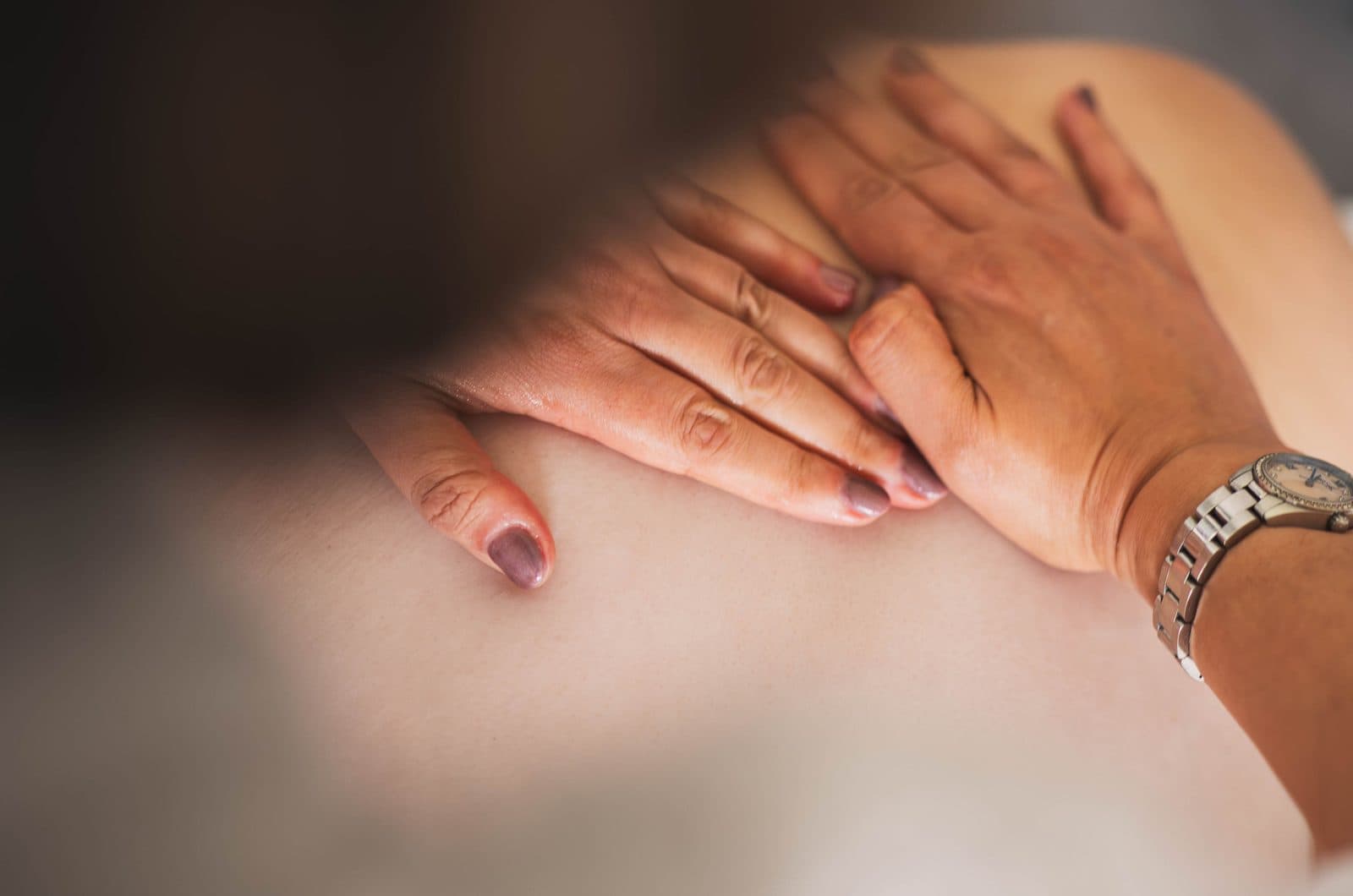 Hands resting gently on the back during a Reiki treatment